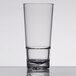 A close up of a Libbey Tritan plastic beverage glass filled halfway with a clear drink.