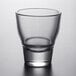 An Arcoroc clear glass shot glass on a table.