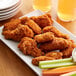 A plate of Brakebush Zippity Doo-Wa Ditties spicy breaded chicken wings with celery and carrots.