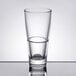An Arcoroc stackable highball glass filled with water on a table.