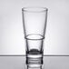 An Arcoroc stackable beverage glass filled with water on a table.