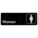 A black rectangular sign with white text that says "Women" and a white woman symbol.