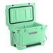 A seafoam green CaterGator outdoor cooler with a handle.