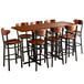 A Lancaster Table & Seating live edge bar height table and chairs set with a wooden table top and boomerang chairs.