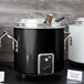 A black and silver Vollrath retro stock pot with a silver lid.