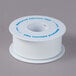 A white spool of Medi-First adhesive tape with blue text on the label.