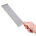 A hand holding a Tablecraft stainless steel spatula server over a white background.