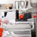 A Vollrath Redco InstaSlice fruit and vegetable cutter on a table with tomatoes.