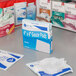 A table with a box of Medi-First sterile gauze pads and other medical supplies.