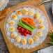 A Fineline plastic egg tray with deviled eggs, carrots, and celery on a table.