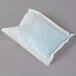 A white Urnex packet with blue powder inside.