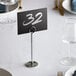 A table setting with a white place card in a Choice chrome menu holder on a table in a fine dining restaurant.