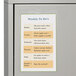 A metal cabinet with a weekly schedule in a C-Line double-sided shop ticket holder.
