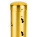 A gold wall-mounted Aarco cigarette and ash receptacle cylinder with two holes.