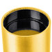 A gold wall mounted metal cylinder with a black center.