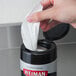 A hand using a Weiman Stainless Steel Cleaning Wipe to clean a surface.