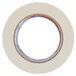 A white Shurtape roll of masking tape with orange and white stripes around the circle in the middle.