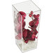 A Cal-Mil clear acrylic square accent vase with red flowers inside.