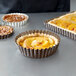 A close-up of a quiche in a Gobel fluted deep tart pan with a removable bottom.