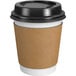 A Choice white paper coffee cup with a black lid and sleeve.