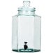 A clear glass jar with a black tap and lid.