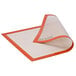 A white SILPAT silicone full-size baking mat with an orange and red border.
