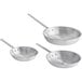 A group of three silver aluminum frying pans with handles