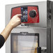 A person using the digital keypad on a Vulcan Mini-Jet electric combi oven.