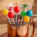 A cup of candy with Paper Lollipop Sticks in it.