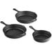 A close-up of a Valor pre-seasoned cast iron skillet set with three black skillets.