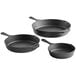 A group of black Choice pre-seasoned cast iron skillets of varying sizes.