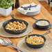 A table with three Choice pre-seasoned cast iron skillets and food on it.