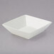 An American Metalcraft white porcelain square bowl on a gray surface.