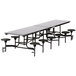 A long rectangular table with black stools on it.