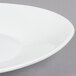 A CAC Super White porcelain triangular coupe salad plate with a small rim.