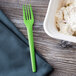 A green Eco-Products Plantware plastic fork next to a bowl of white food.