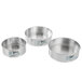 A set of three round silver metal springform cake pans with metal handles.