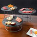 A Choice Chrome Plated Steel 3-Piece Display Stand Set with black plates of cheese and meat on a table.