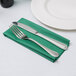 A Hunter green flat pack linen-like napkin with a fork and knife on it.