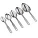 A close-up of several silver Vollrath stainless steel oval measuring spoons.