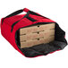 A red Cambro insulated bag holding pizza boxes.