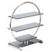 A Bon Chef stainless steel and glass wheel display stand with three glass shelves in a round metal frame.
