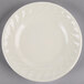 A Tuxton Meridian ivory china plate with a swirl design on the rim.