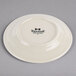 A Tuxton Meridian ivory china plate with an embossed swirl rim and black text on it.