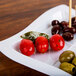 A Fineline white disposable plastic tray with olives and tomatoes on sticks.