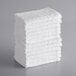A stack of Lavex white cotton/poly washcloths.