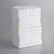 A stack of Lavex white bath towels.