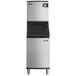 A stainless steel Manitowoc air cooled ice machine with black and silver rectangular compartments.
