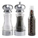 A white salt shaker and two clear pepper mills with black and white pepper inside.