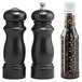 A black pepper mill and salt shaker set on a counter.